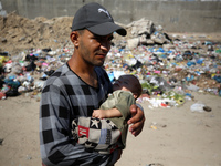 Palestinians are walking past sewage water and a garbage dump on a street in Deir el-Balah in the central Gaza Strip, on July 23, 2024, as m...