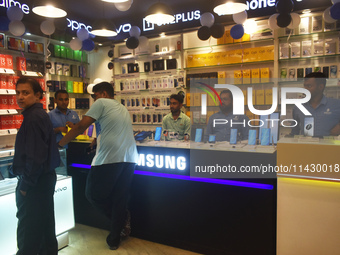 People are shopping inside a store selling mobile phones and accessories in Kolkata, India, on July 23, 2024. (