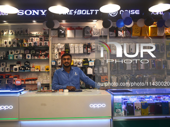 A person is selling mobile phones and accessories inside a store in Kolkata, India, on July 23, 2024. (