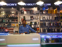 A person is selling mobile phones and accessories inside a store in Kolkata, India, on July 23, 2024. (