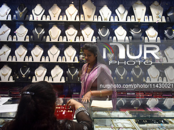 A woman is checking ornaments at a jewelry shop in Kolkata, India, on July 23, 2024. (