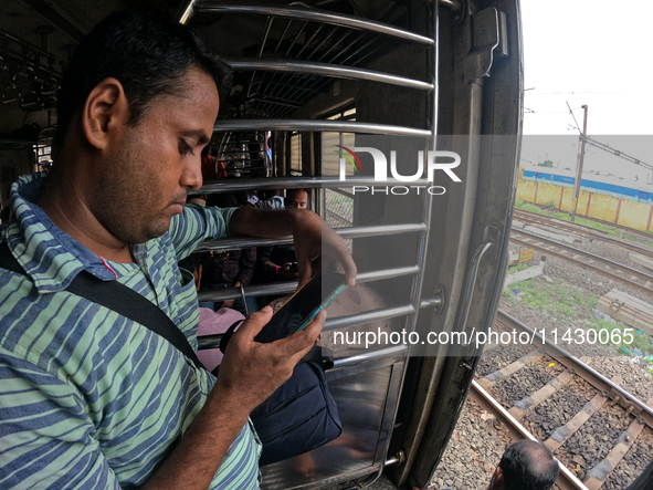 A passenger is watching his smartphone live streaming Union Finance Minister Nirmala Sitharaman's budget speech inside a general compartment...