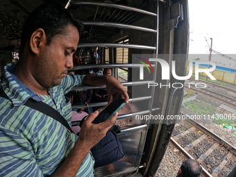 A passenger is watching his smartphone live streaming Union Finance Minister Nirmala Sitharaman's budget speech inside a general compartment...