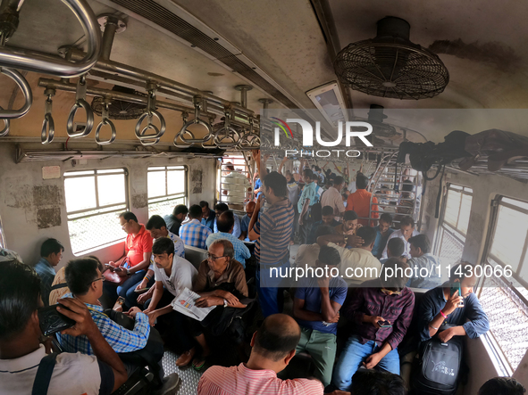 An Indian is traveling in a local train in the outskirts of Kolkata, India, on July 23, 2024. 