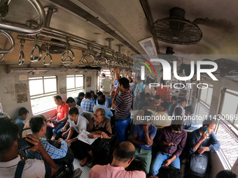 An Indian is traveling in a local train in the outskirts of Kolkata, India, on July 23, 2024. (