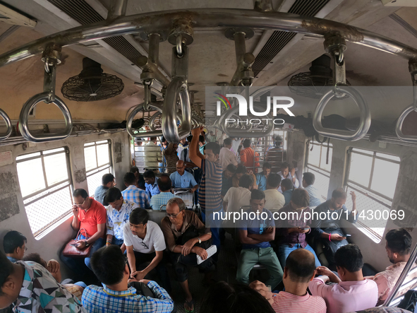 An Indian is traveling in a local train in the outskirts of Kolkata, India, on July 23, 2024. 