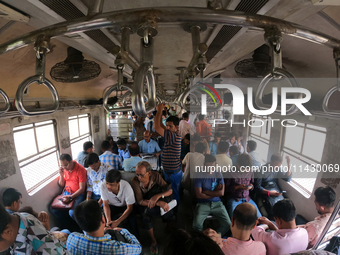 An Indian is traveling in a local train in the outskirts of Kolkata, India, on July 23, 2024. (