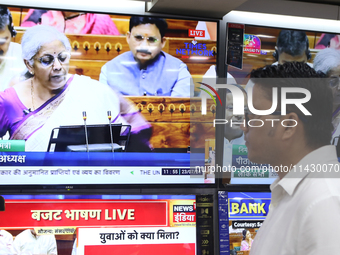 People are watching TV live as Union Finance Minister Nirmala Sitharaman addresses at an electronic shop in Kolkata, India, on July 23, 2024...