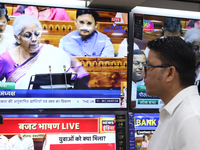 People are watching TV live as Union Finance Minister Nirmala Sitharaman addresses at an electronic shop in Kolkata, India, on July 23, 2024...