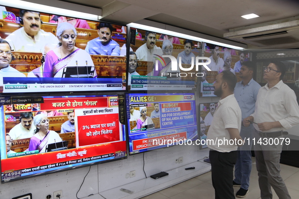 People are watching TV live as Union Finance Minister Nirmala Sitharaman addresses at an electronic shop in Kolkata, India, on July 23, 2024...