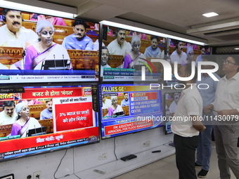 People are watching TV live as Union Finance Minister Nirmala Sitharaman addresses at an electronic shop in Kolkata, India, on July 23, 2024...