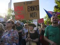 A woman is holding a sign reading ''Woman = Human Embryo not!'' as she is taking part in a rally in favour of free and safe abortion in Wars...