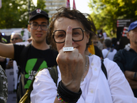 A woman is showing the middle finger as she is wearing a ring that reads ''Fuck off'' during a rally in favor of free and safe abortion in W...