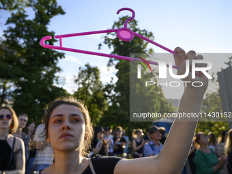 A woman is holding a cloth hanger as she is taking part in a rally in favor of free and safe abortion in Warsaw, Poland, on July 23, 2024. H...