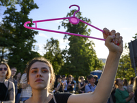 A woman is holding a cloth hanger as she is taking part in a rally in favor of free and safe abortion in Warsaw, Poland, on July 23, 2024. H...