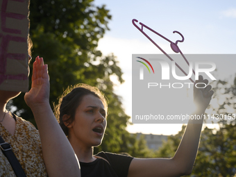 A woman is holding a cloth hanger as she is taking part in a rally in favor of free and safe abortion in Warsaw, Poland, on July 23, 2024. H...