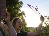 A woman is holding a cloth hanger as she is taking part in a rally in favor of free and safe abortion in Warsaw, Poland, on July 23, 2024. H...