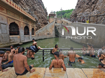 Youth are cooling off in the holy pond 'Kund' of Shrine Galta Peeth Tirtha, also famous as 'Galta Ji temple' and 'Monkey temple', in Jaipur,...