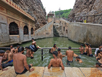 Youth are cooling off in the holy pond 'Kund' of Shrine Galta Peeth Tirtha, also famous as 'Galta Ji temple' and 'Monkey temple', in Jaipur,...