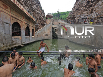 Youth are cooling off in the holy pond 'Kund' of Shrine Galta Peeth Tirtha, also famous as 'Galta Ji temple' and 'Monkey temple', in Jaipur,...