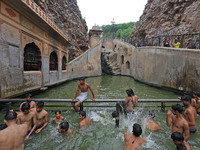 Youth are cooling off in the holy pond 'Kund' of Shrine Galta Peeth Tirtha, also famous as 'Galta Ji temple' and 'Monkey temple', in Jaipur,...