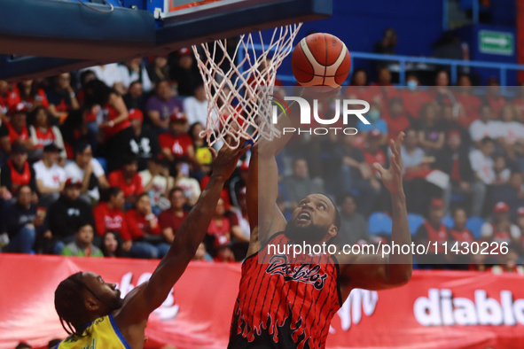 Maique Tavares #35 of Diablos Rojos is slam dunking during the National Professional Basketball League (LNBP) game between Diablos Rojos and...