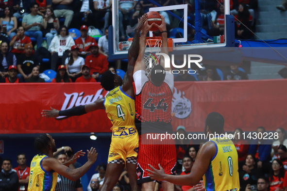 Joshua Ibarra #44 of Diablos Rojos is slam dunking against Mario Kegler #4 of the Santos during the National Professional Basketball League...