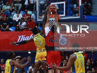 Joshua Ibarra #44 of Diablos Rojos is slam dunking against Mario Kegler #4 of the Santos during the National Professional Basketball League...