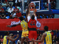 Joshua Ibarra #44 of Diablos Rojos is slam dunking against Mario Kegler #4 of the Santos during the National Professional Basketball League...