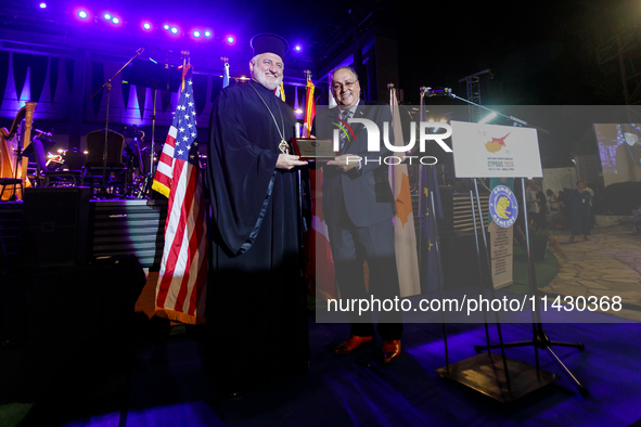 Archbishop ELPIDOPHOROS of America (L) is receiving a commemorative plaque from Supreme President SAVAS TSIVICOS (R) during the ceremony in...