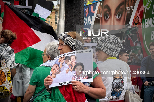 A woman is demonstrating in support of Palestine to stop the genocide of Palestinians and to exclude Israel from the Paris Olympics at the '...