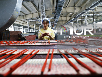 A worker is producing pencils at a production workshop in Suqian, Jiangsu province, China, on July 24, 2024. (