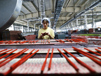 A worker is producing pencils at a production workshop in Suqian, Jiangsu province, China, on July 24, 2024. (