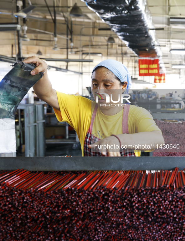 A worker is producing pencils at a production workshop in Suqian, Jiangsu province, China, on July 24, 2024. 