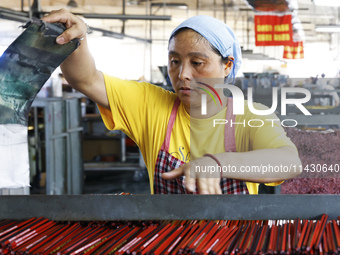 A worker is producing pencils at a production workshop in Suqian, Jiangsu province, China, on July 24, 2024. (