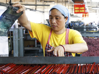 A worker is producing pencils at a production workshop in Suqian, Jiangsu province, China, on July 24, 2024. (