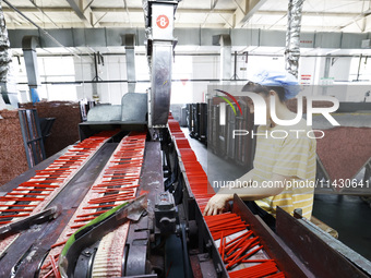 A worker is producing pencils at a production workshop in Suqian, Jiangsu province, China, on July 24, 2024. (