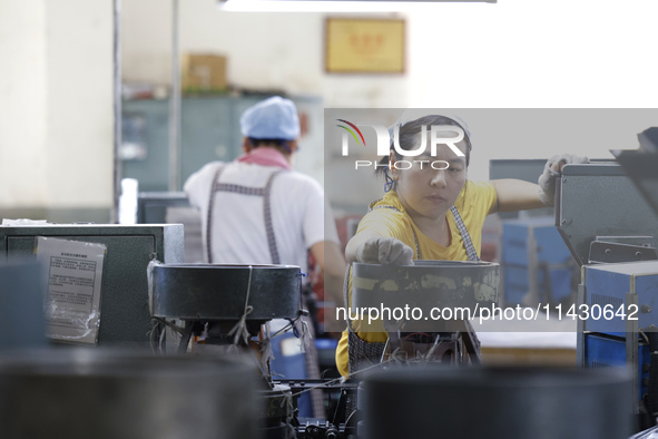 A worker is producing pencils at a production workshop in Suqian, Jiangsu province, China, on July 24, 2024. 