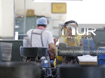 A worker is producing pencils at a production workshop in Suqian, Jiangsu province, China, on July 24, 2024. (