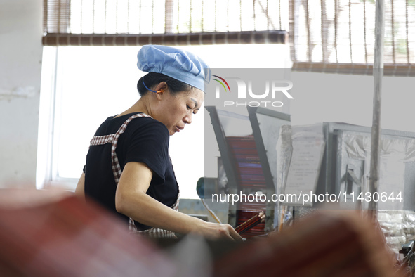 A worker is producing pencils at a production workshop in Suqian, Jiangsu province, China, on July 24, 2024. 