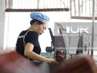 A worker is producing pencils at a production workshop in Suqian, Jiangsu province, China, on July 24, 2024. (