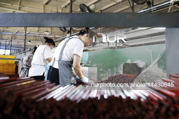 A worker is producing pencils at a production workshop in Suqian, Jiangsu province, China, on July 24, 2024. 