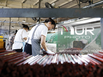 A worker is producing pencils at a production workshop in Suqian, Jiangsu province, China, on July 24, 2024. (