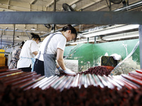 A worker is producing pencils at a production workshop in Suqian, Jiangsu province, China, on July 24, 2024. (