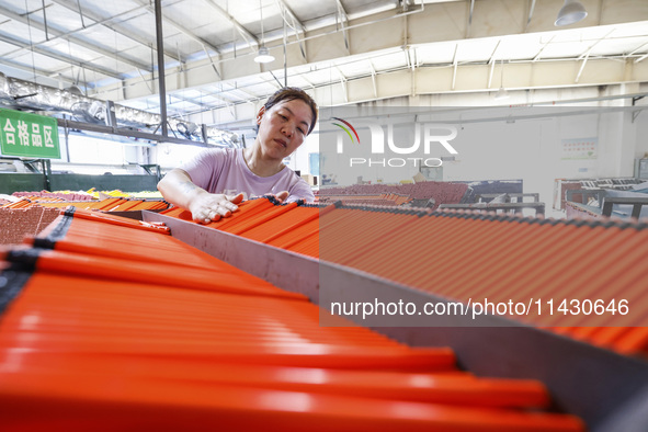 A worker is producing pencils at a production workshop in Suqian, Jiangsu province, China, on July 24, 2024. 