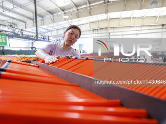 A worker is producing pencils at a production workshop in Suqian, Jiangsu province, China, on July 24, 2024. (