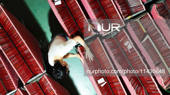 A worker is producing pencils at a production workshop in Suqian, Jiangsu province, China, on July 24, 2024. 