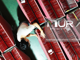 A worker is producing pencils at a production workshop in Suqian, Jiangsu province, China, on July 24, 2024. (