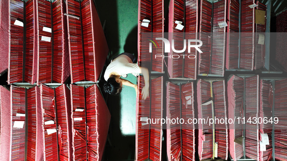 A worker is producing pencils at a production workshop in Suqian, Jiangsu province, China, on July 24, 2024. 