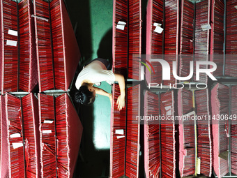 A worker is producing pencils at a production workshop in Suqian, Jiangsu province, China, on July 24, 2024. (